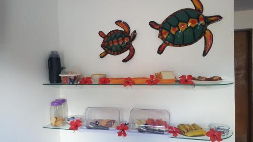 a shelf with three fish on it with dishes on it at Flat Visual do Porto in Fernando de Noronha