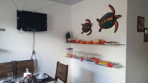 a dining room with a table and two shelves on the wall at Flat Visual do Porto in Fernando de Noronha