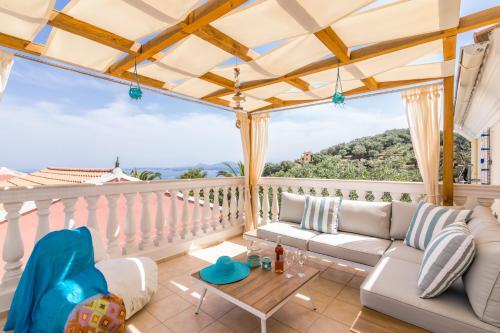 a balcony with a couch and a table at Villa kortilles in Pyrgi