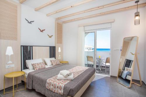 a bedroom with a bed and a view of the ocean at Alexander Studios & Suites - Adults Only in Faliraki