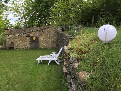 a white bench sitting in a yard next to a stone building at Weekend en Provence in Comps