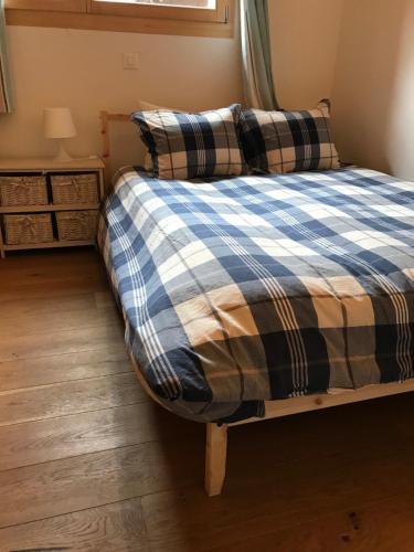 ein Schlafzimmer mit einem Bett mit einer karierten Decke in der Unterkunft Apartment Elin 1 in Le Châble