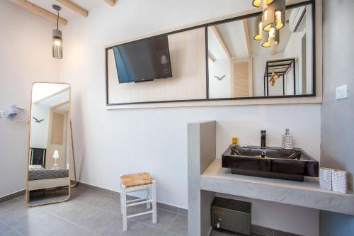 a bathroom with a sink and a mirror at Alexander Studios & Suites - Adults Only in Faliraki
