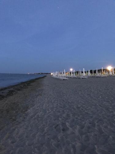 a beach at night with a row of umbrellas at Casa Mara in Chioggia