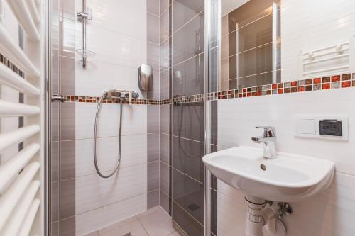 een witte badkamer met een douche en een wastafel bij Hostel Biały Dom in Krakau