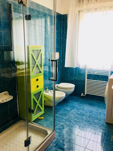 a bathroom with a toilet and a glass shower at Casa Gabbiano in Nago-Torbole