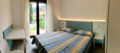 1 dormitorio con cama y ventana grande en Casa Gabbiano, en Nago-Torbole
