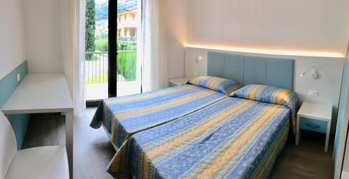 a bedroom with a bed and a large window at Casa Gabbiano in Nago-Torbole