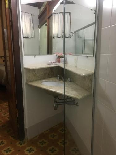 a bathroom with a sink and a mirror at Calcada Sao Jose in Tiradentes
