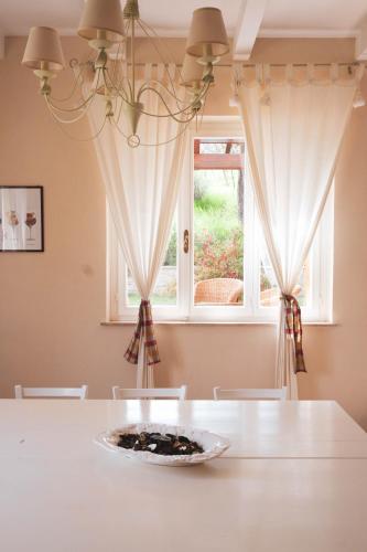 a dining room with a white table and a window at Azienda ASIS in Monterubbiano