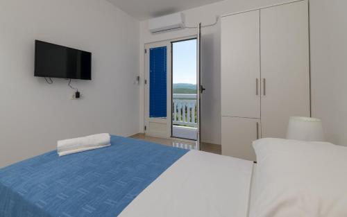 a white bedroom with a bed and a television at Villa Doris in Neum