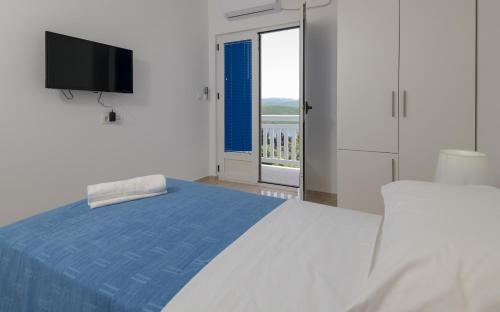 a bedroom with a bed and a tv and a window at Villa Doris in Neum