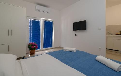 a bedroom with a large bed with a blue blanket at Villa Doris in Neum