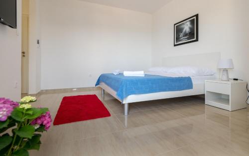 a bedroom with a bed and a red rug at Villa Doris in Neum