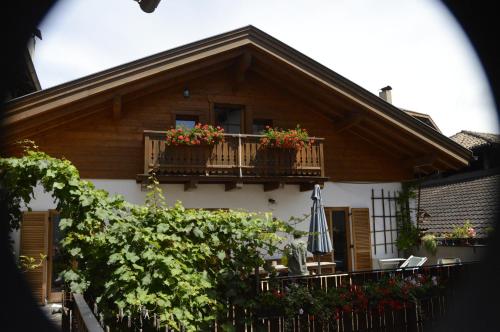 una casa con un balcón con flores. en Mansarde en Cornaiano