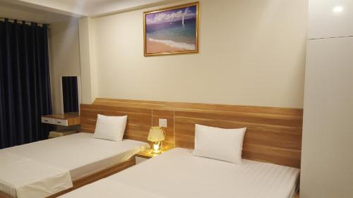 a bedroom with two beds and a picture on the wall at Sky in Ha Long