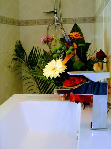 a bathroom with a sink with a bouquet of flowers at Villa arbre du voyageur, 4 étoiles et 4 clévacances in LʼEntre-Deux