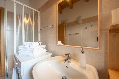 a bathroom with a sink and a mirror and towels at Cèsa Castlunger in Canazei