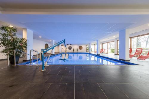 - une piscine dans un hôtel avec une grande chambre dans l'établissement Hotel Masatsch, à Caldaro