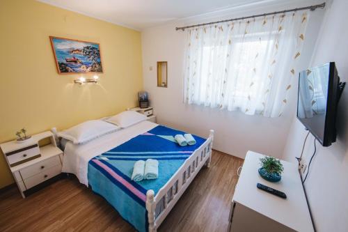 um pequeno quarto com uma cama e uma televisão em Apartment Danica em Split