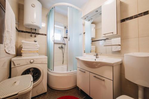 uma casa de banho com uma máquina de lavar roupa e um lavatório em Apartment Danica em Split