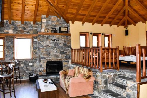 una gran sala de estar con chimenea de piedra. en Guest House "Aspasia", en Lavkos