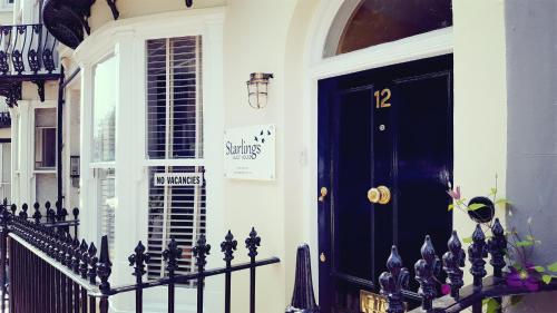 a black door on a house with a black fence at Starlings Guest House in Brighton & Hove