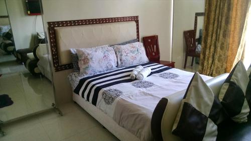 a bed with a teddy bear sitting on top of it at 3N Palm Tree Villas in Manila