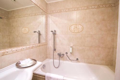 a bathroom with a bath tub and a sink at Karlsbad Grande Madonna in Karlovy Vary