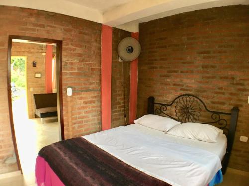 a bed in a room with a brick wall at Cabañas La Carolina - Mesa de Los Santos in Los Santos