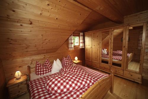 a bedroom with two beds in a log cabin at Almhaus Pleschinhof in Hochrindl