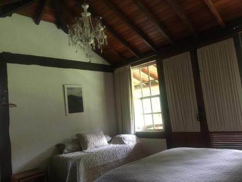 a bedroom with two beds and a chandelier at Calcada Sao Jose in Tiradentes