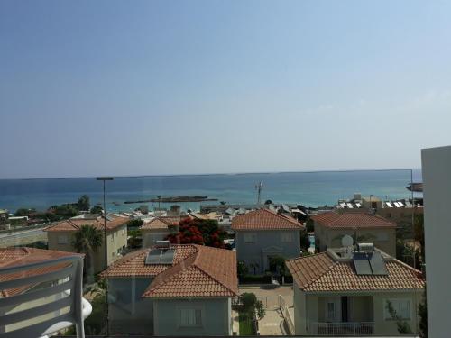 a view of a city with houses and the ocean at Protaras Plaza Hotel in Protaras