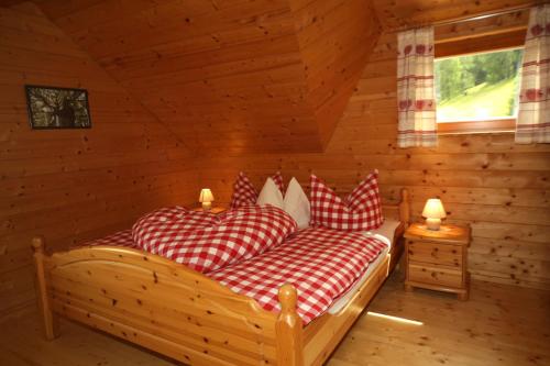 a bedroom with two beds in a log cabin at Almhaus Pleschinhof in Hochrindl