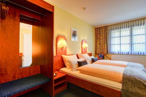 a hotel room with a bed and a mirror at Hotel Elbinsel free parking in Hamburg