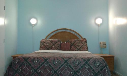 a bedroom with a bed with two lights on the wall at Hotel Caribe in Santa Cruz de Barahona