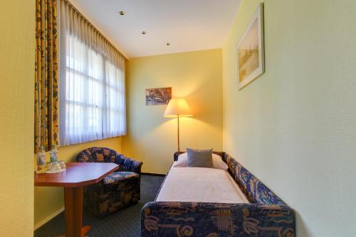 a hotel room with a bed and a table and a window at Hotel Elbinsel free parking in Hamburg