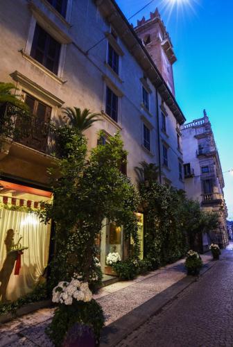 a building on a cobblestone street in front of a building at Hotel Gabbia D'Oro in Verona
