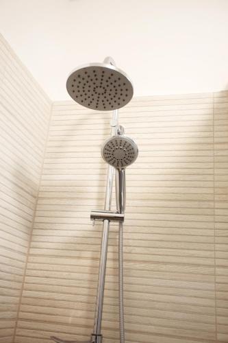 a shower with a stool with a shower head at Rox Central Apartments 3 in Timişoara