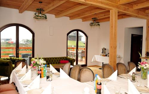 a dining room with white tables and chairs at Dom nad Rozlewiskiem in Zamość