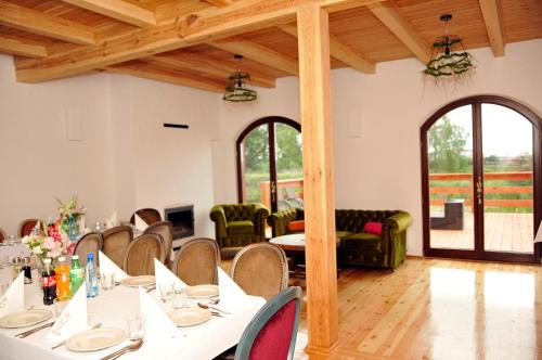 a dining room with white tables and chairs at Dom nad Rozlewiskiem in Zamość