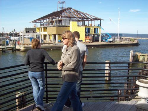 a group of people standing on a dock with a building at Captain's villa in Molunat
