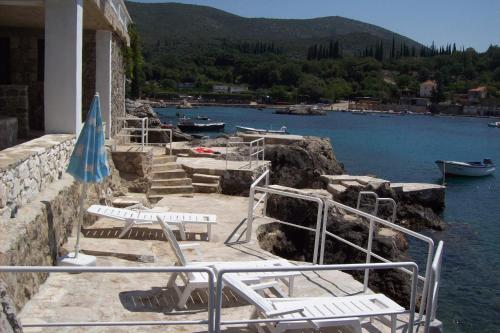 a group of chairs sitting on a ledge next to the water at Captain's villa in Molunat
