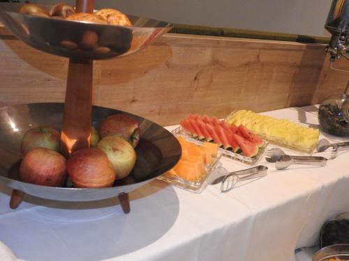 a table with a bowl of fruit and a plate of food at Hotel Sonnenhof in Marlengo