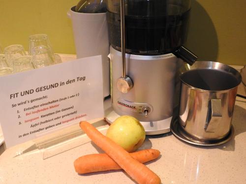 a blender and some carrots and an apple on a counter at Hotel Sonnenhof in Marlengo