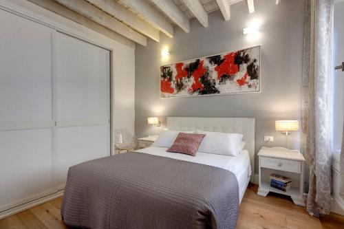 a bedroom with a bed and a painting on the wall at De Rustici Apartment in Florence