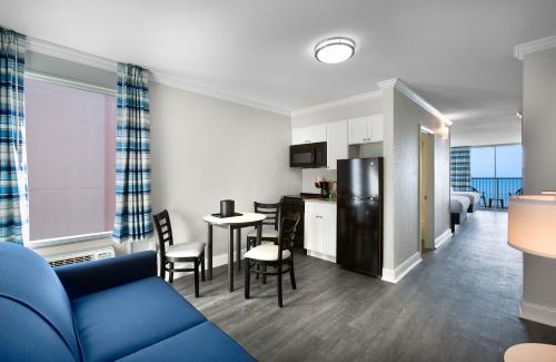 a living room with a blue couch and a kitchen at Compass Cove in Myrtle Beach