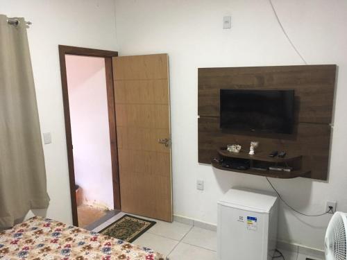 um quarto com uma cama e uma televisão de ecrã plano em Suite independente em casa de fazenda em Capitólio