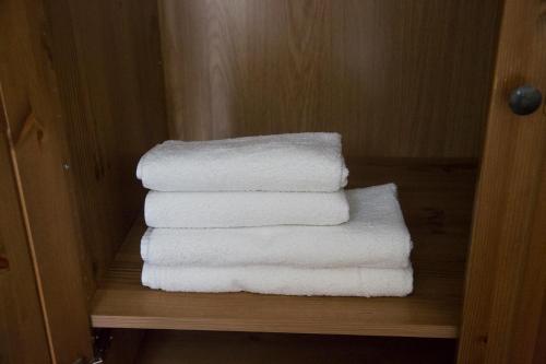 ein Stapel weißer Handtücher auf einem Regal in der Unterkunft Apartamento Torcal Écija in Écija