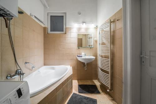 a bathroom with a tub and a sink at Nyár 3 Bedroom Centre Entire Home in Budapest